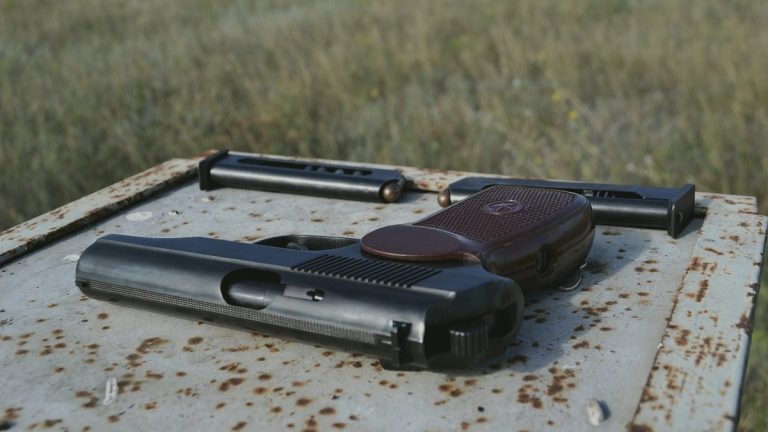 Well-worn pistol and magazines on a weathered steel table