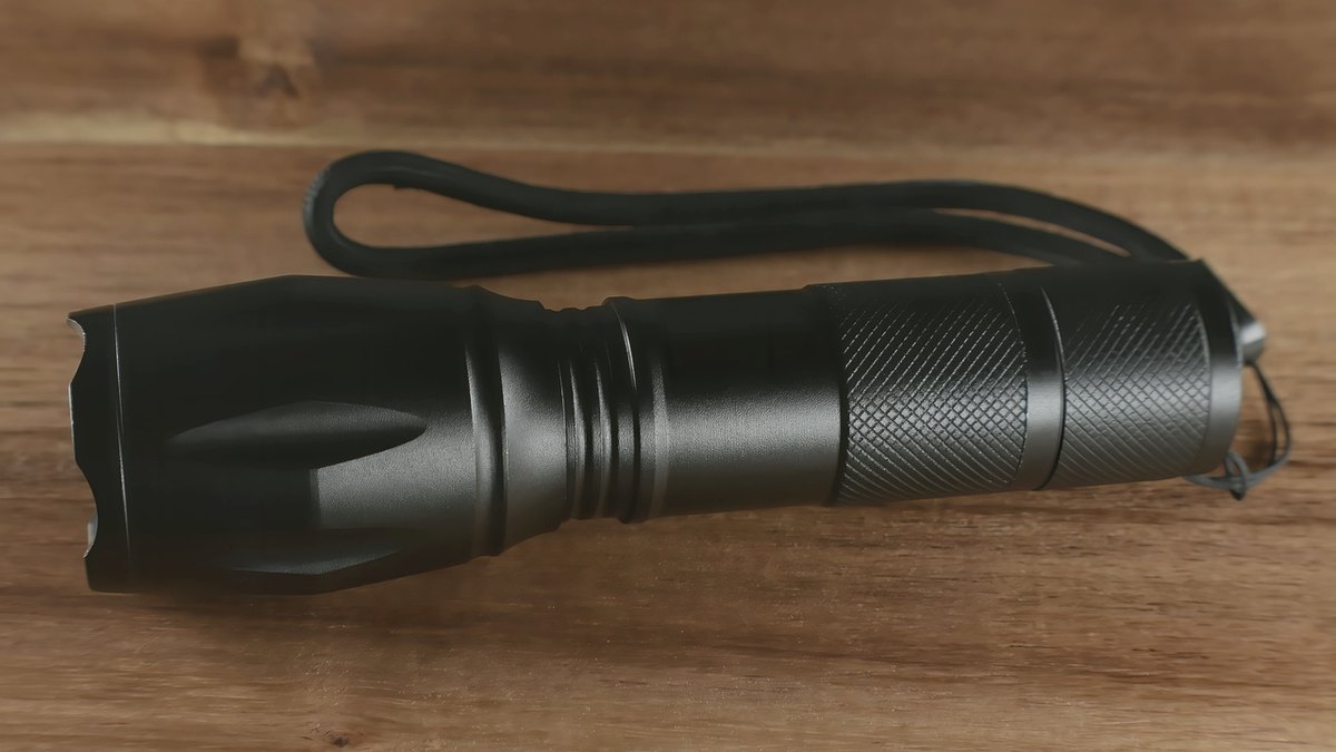 Handheld LED flashlight on a wooden table